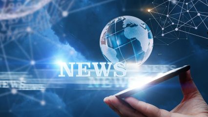 A globe balanced on a cellphone with the word "News" off to the side