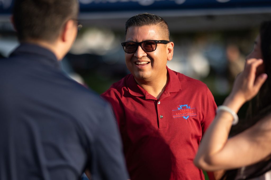 Jesse Armendarez shaking a mans hand at an outdoor event