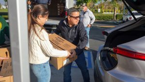 Jesse Armendarez helping a women place a box in the trunk of a car