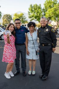 Jesse Armendarez with 2 women and a police officer in a parking lot.