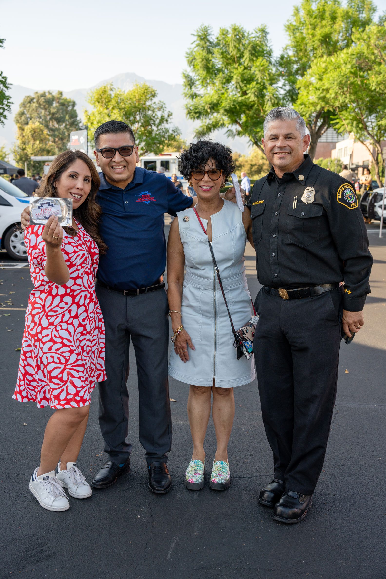 Jesse Armendarez with 2 women and a police officer in a parking lot.