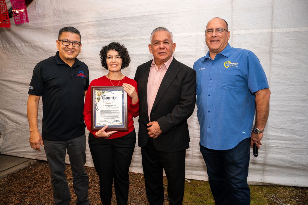 Jesse Armendarez with 2 men and a woman holding a certificate of recognition for a restaurant in Upland, CA