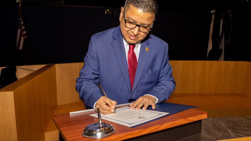 Supervisor Baca, Jr. signs a document